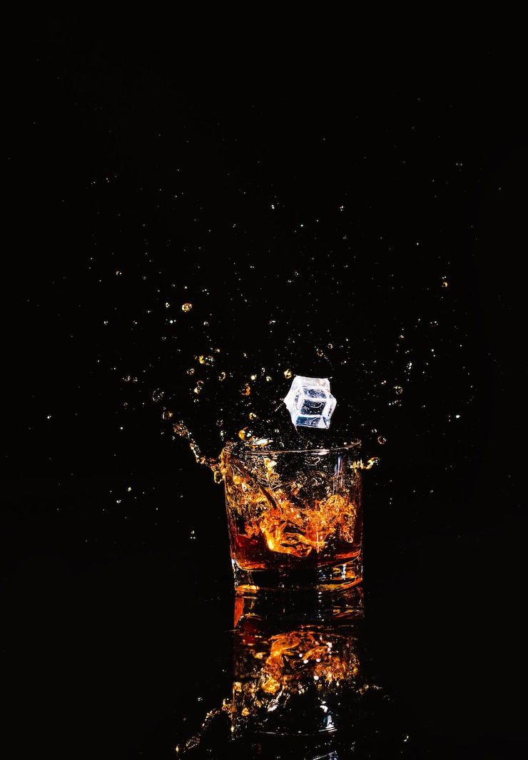 Whisky con schizzi su sfondo nero
