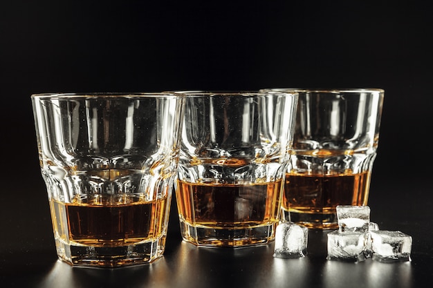 Whisky e ghiaccio su legno rustico