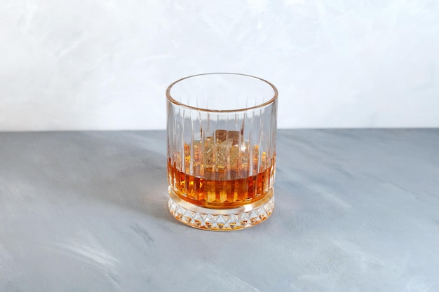 Whisky on the rocks o scotch con cubetti di ghiaccio in bicchiere Old fashion. Bevanda alcolica con ghiaccio.