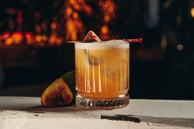 Whisky sour cocktail con fichi in bicchiere old fashioned
