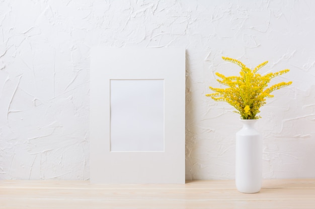 White mat frame mockup with ornamental yellow flowering grass in vase