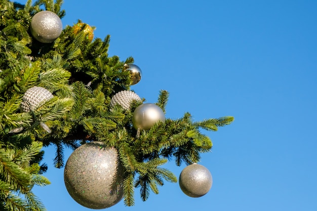 White New Year decorazioni e ghirlanda su un ramo di albero di Natale artificiale all'aperto