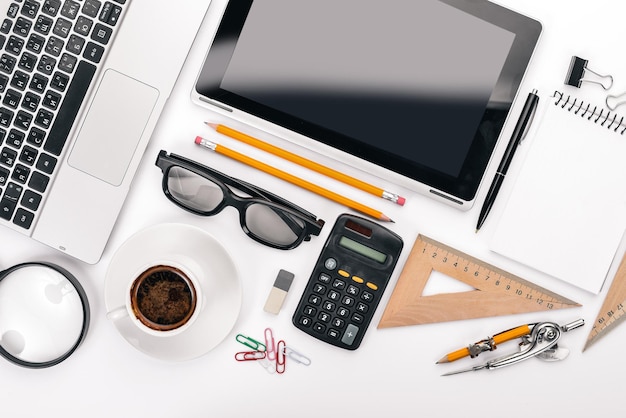 White Office Desk Laptop telefono tazza di caffè occhiali penna matita su sfondo bianco Vista dall'alto Spazio libero per il testo