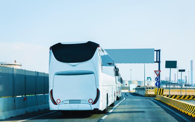 White Shuttle bus di nuovo in strada, Italia. Traffico di trasporto pubblico moderno e guida estiva. Noleggio di veicoli in pullman durante il viaggio di vacanza. Viaggio di vacanza per la ricreazione. Moto e corsa urbana.