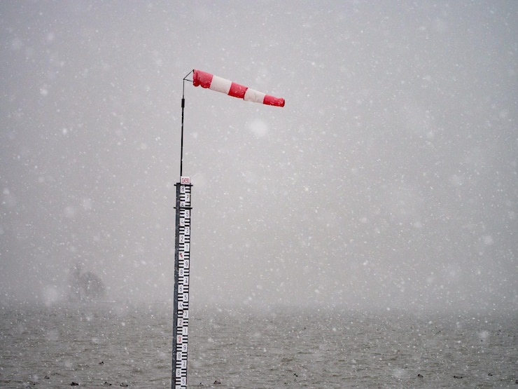 Foto windsock su un palo in mare contro il cielo durante il tempo innevato