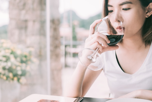 Wine tasting tourist woman. Giovane donna che beve vino in un ristorante in stile italiano