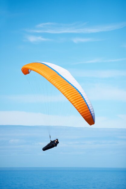 Wings over water Inquadratura di un uomo in parapendio in una giornata di sole