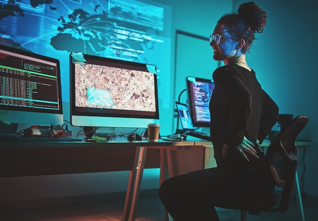 woman back pain and computer programmer software engineering or cybersecurity at night stress and pain fatigue spine problem and tired it person on monitor satellite coding or data surveillance