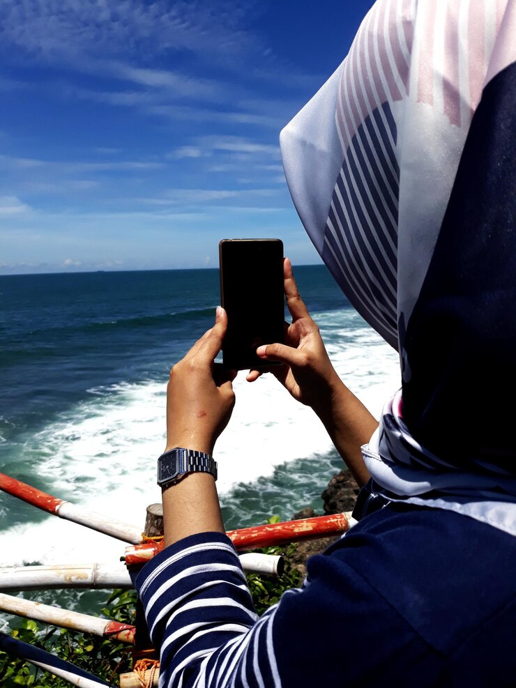 Photo woman photographing on sea against sky