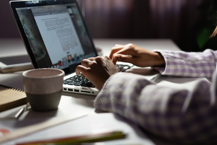 Photo woman uses a laptop while working on a new project idea late evening. female hands are typing on laptop keyboard
