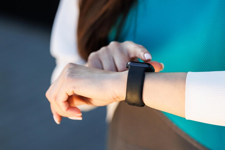 Woman uses a smart watch to measure the pulse on the hands A woman does sports on the street Fitness and a healthy lifestyle