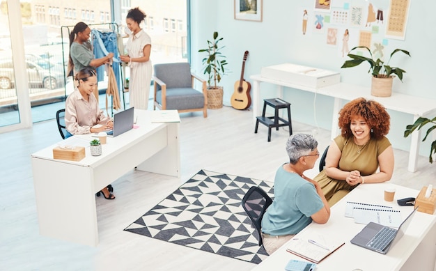 Workshop di gruppo di designer e donne della moda con laptop che parlano e pianificano con idee, creatività o obiettivi Startup aziendale e lavoro di squadra con abiti in tessuto e supporto per la visione a Cape Town