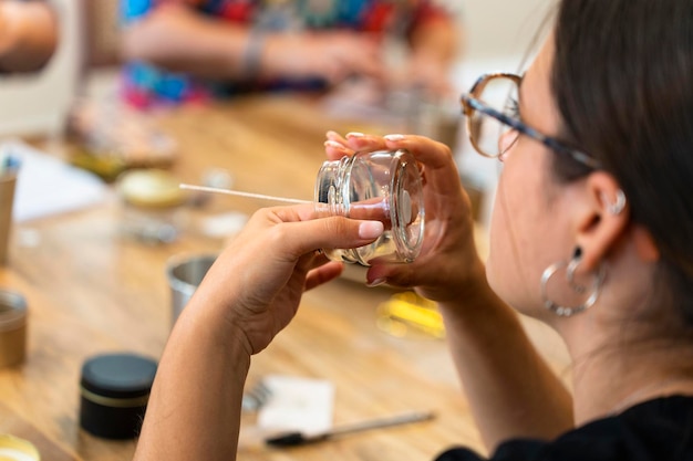 Workshop sulle candele aromatiche Giovane donna che posiziona lo stoppino della candela