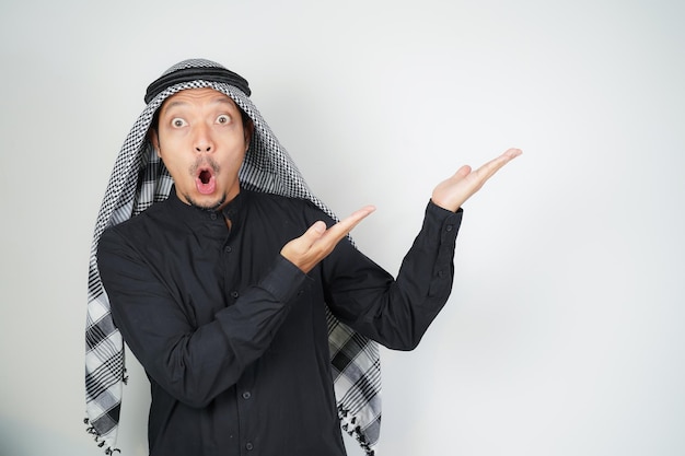 Wow faccia espressione scioccata uomo musulmano asiatico che indossa turbante arabo sorban puntando il dito della mano
