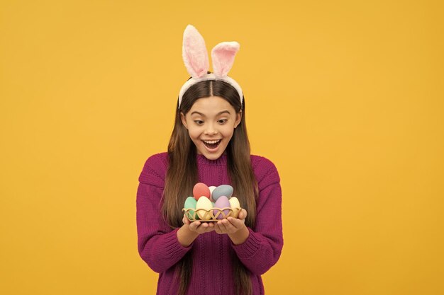 Wow infanzia felice coniglietto bambino tenere uova dipinte felice vacanza di pasqua bambino sorpreso nelle orecchie