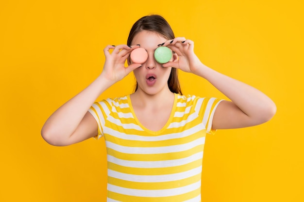 Wow ragazza con macaron su sfondo giallo