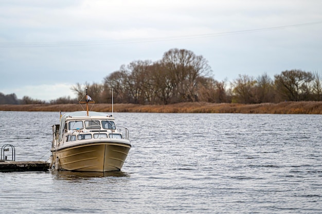 Yacht a motore al molo sulla riva del fiume