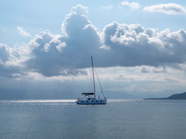 Yacht-catamarano in una giornata nuvolosa sul calmo Mar Egeo sull'isola di Evia, Grecia