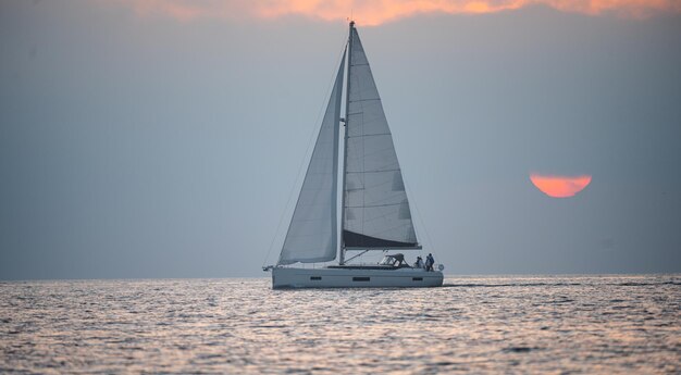 Yacht in mare al tramonto. Navigazione all'alba con barca a vela. Paesaggio di mare e spiaggia tropicale. Natura bellissima vista sul mare. Viaggi e vacanze, copia dello spazio.