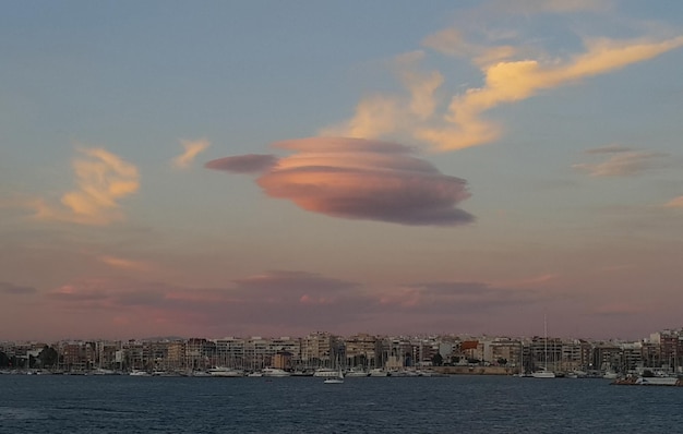 Yacht marini al tramonto in porto e cielo con nuvola ufo