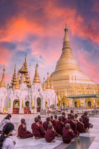 Yangon Myanmar Primavera del 2018 Shwedagon Pagoda un gruppo di monaci buddisti seduti per terra in preghiera