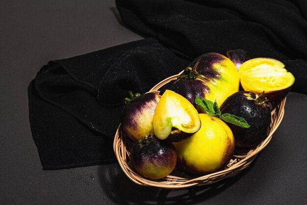 Yellowviolet Varietà di pomodori Colori primari in un cesto di vimini Raccolto di ortaggi maturi