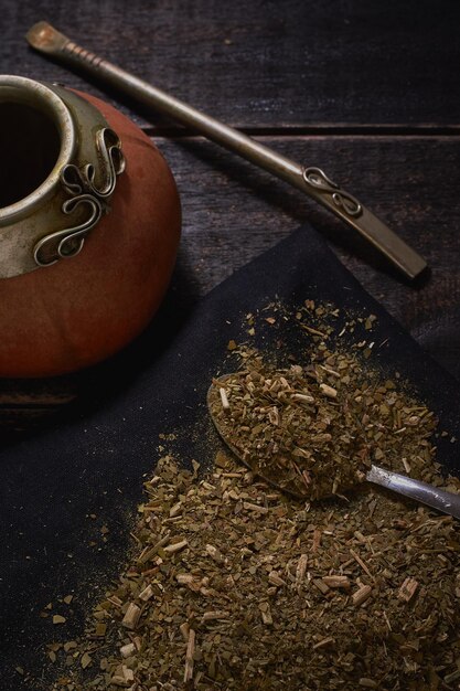 Yerba mate e zucca con bambilla su fondo di legno nero