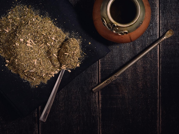 Yerba mate e zucca con bambilla su fondo di legno nero