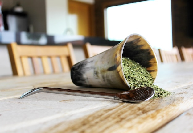 Yerba Mate Una tazza di tè con un cucchiaio su un tavolo accanto.