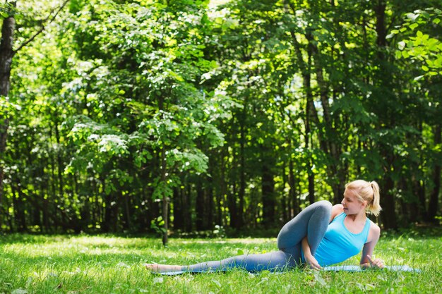 Yoga della giovane donna nel parco