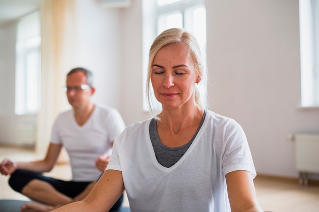 Yoga di pratica della donna e dell'uomo adulto