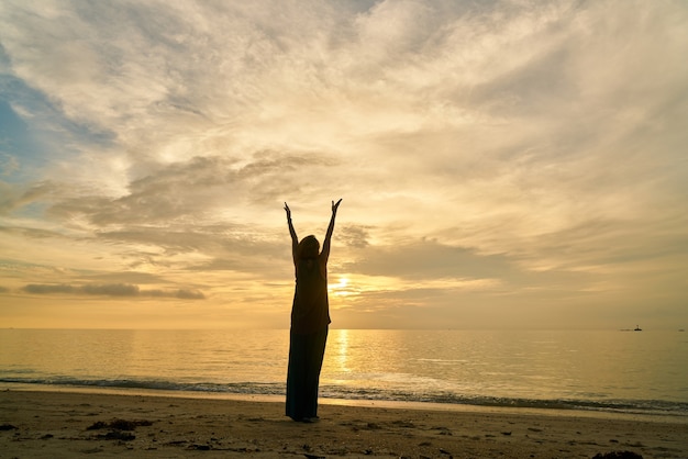 Yoga e donna sulla spiaggia