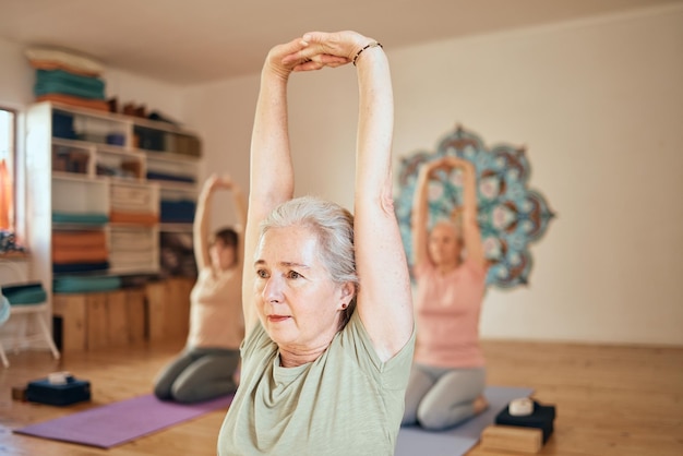 Yoga fitness e donna anziana in studio facendo allenamento stretching e allenamento in classe di ginnastica Pensionamento benessere e donna anziana attiva che fa esercizio di pilates ed equilibrio nella lezione di ginnastica