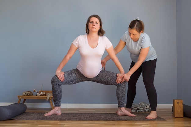 Yoga in gravidanza e concetto di fitness. Modello di yoga incinta che si allena indoo facendo la posa di Rudrasana o Godness