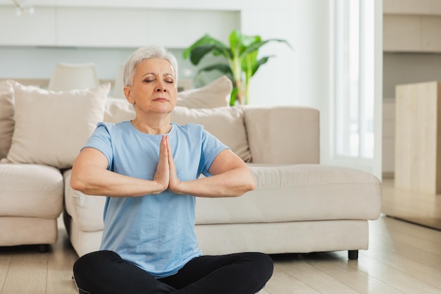 Yoga mindfulness meditazione adulti anziani donna matura che pratica yoga a casa signora anziana di mezza età