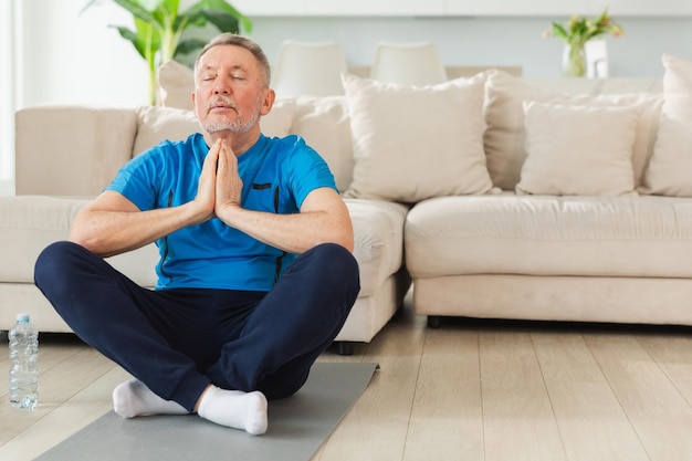 Yoga mindfulness meditazione adulto anziano uomo maturo che pratica yoga a casa nonno anziano di mezza età