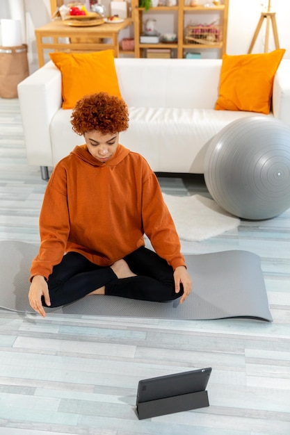 Yoga mindfulness meditazione giovane ragazza africana sana che pratica yoga a casa donna seduta in