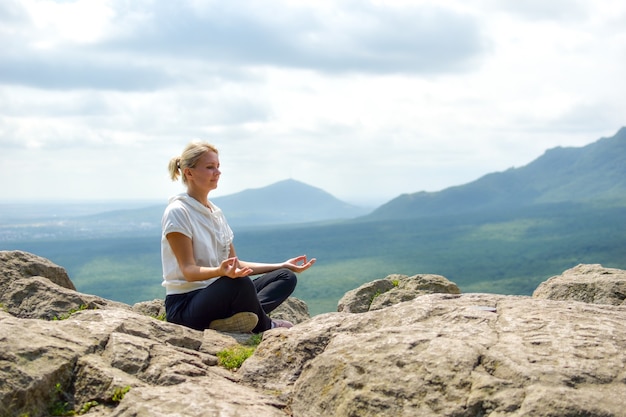 Yogi turistico della donna sulla cima della montagna. Godersi la natura.