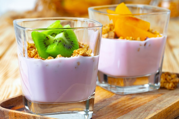 Yogurt ai frutti di bosco con muesli e frutta in un bicchiere