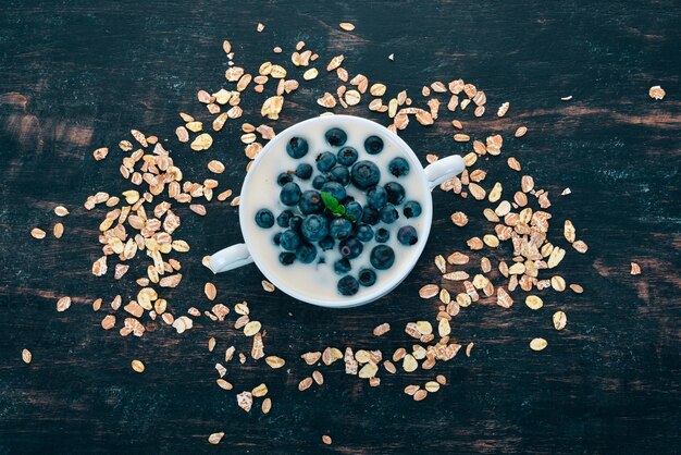 Yogurt con colazione ai mirtilli su fondo in legno Vista dall'alto Spazio libero per il testo