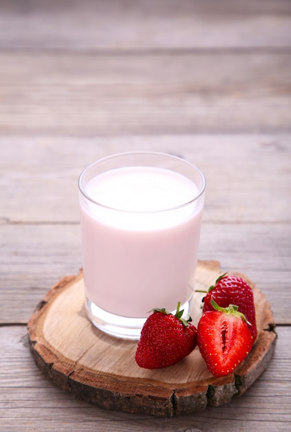 Yogurt con fragole in vetro su legno grigio