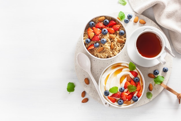 Yogurt con fragole, mirtilli, miele, mandorle e quinoa per colazione