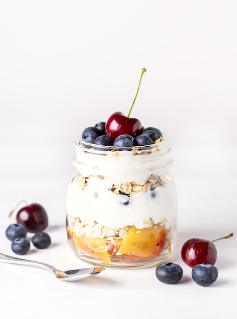 Yogurt con frutta di farina d'avena e bacche Dieta sana colazione bianco rustico sfondo di legno verticale