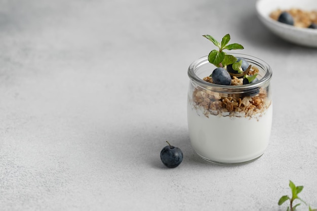 Yogurt con mirtilli e muesli in un vasetto di vetro