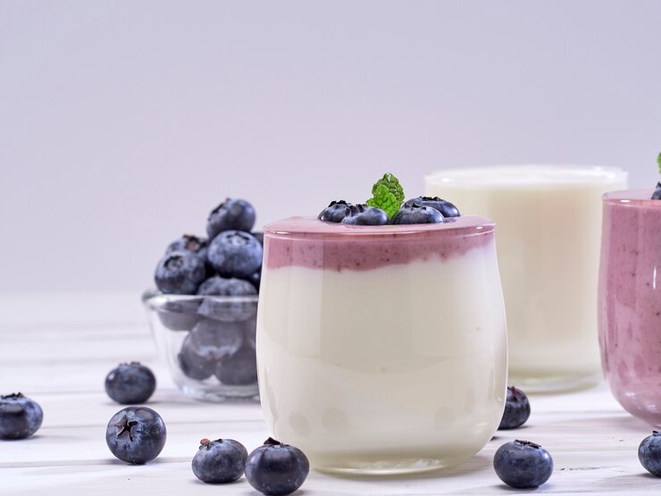 Yogurt di mirtilli e yogurt bianco su un tavolo di legno