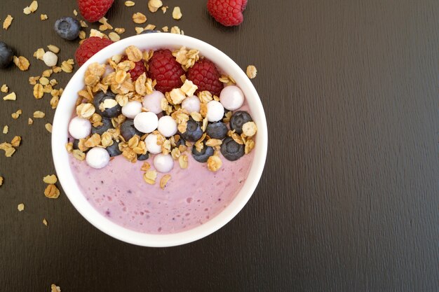 Yogurt di mirtillo con le bacche fresche su una tavola di legno.