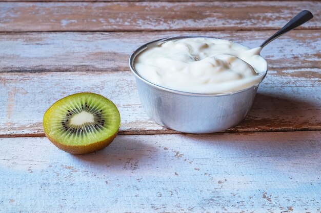 Yogurt e kiwi naturali sulla tavola di legno