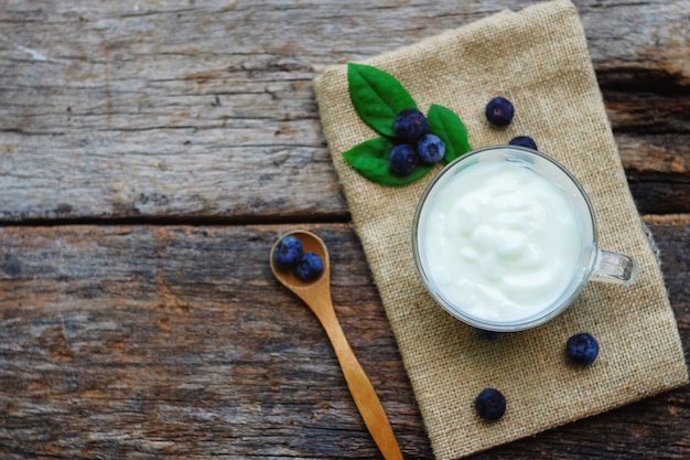 yogurt e mirtillo sul fondo della tavola di legno.