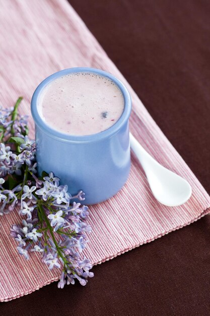 Yogurt fatto in casa con frutti di bosco e un bouquet di fiori primaverili