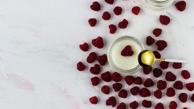 Yogurt fatto in casa con lamponi Vasetti di yogurt circondati da lamponi Vista dall'alto